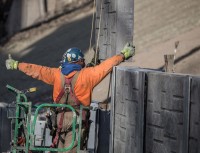 lhv precast employee guiding crane to place a concrete wall segment.